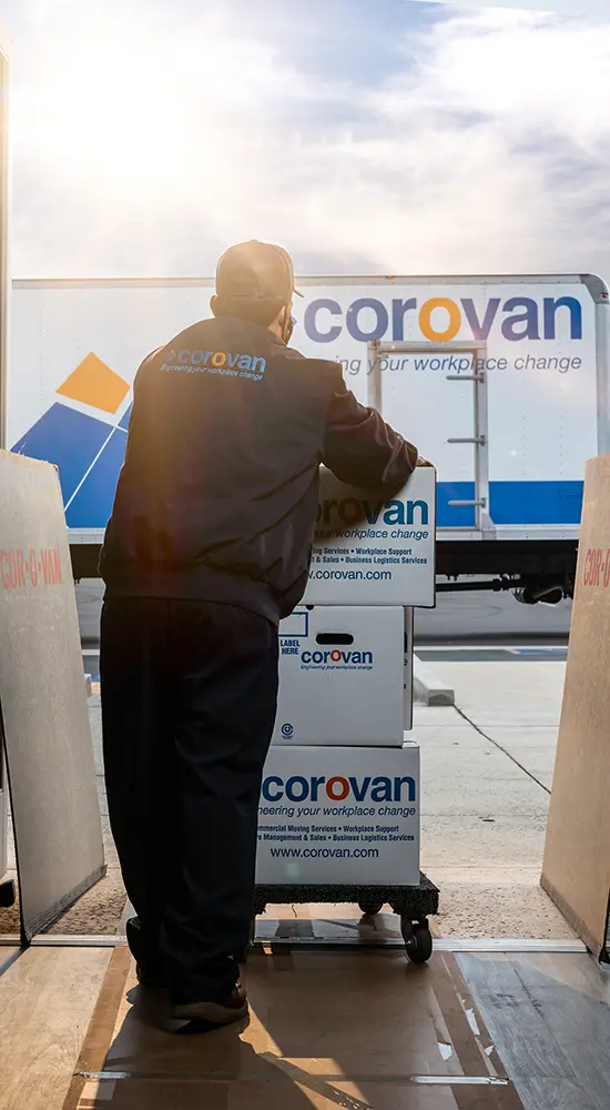 worker moving items with dolly to corovan moving truck